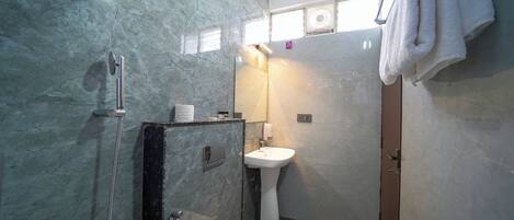 A bathroom with a shower, toilet, and sink.