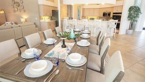 Un comedor con una mesa larga dispuesta para una comida, rodeada de sillas.
