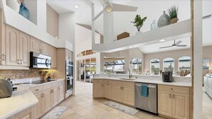 Una cocina moderna con techos altos, electrodomésticos integrados y una isla grande.
