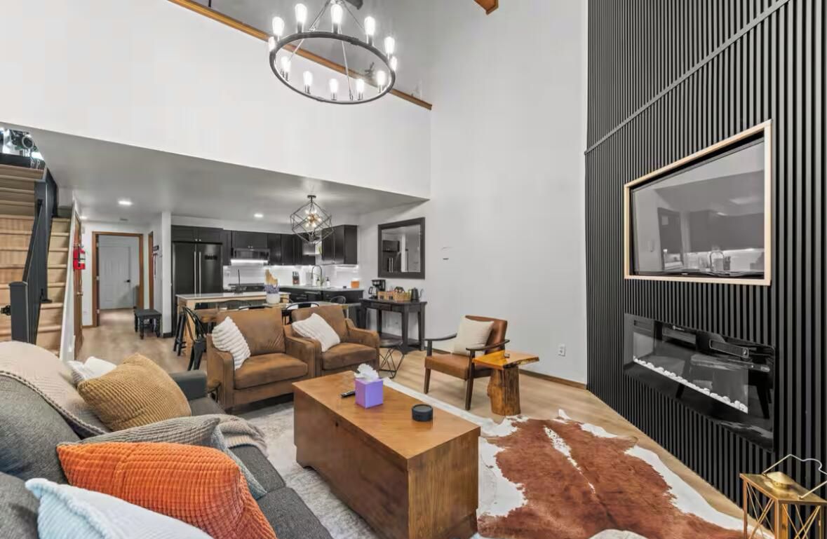 A modern living area with a sofa, coffee table, and a TV mounted on a wall.