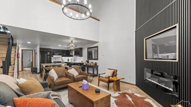 Ein modernes Wohnzimmer mit Sofa, Couchtisch und einem an der Wand befestigten Fernseher.