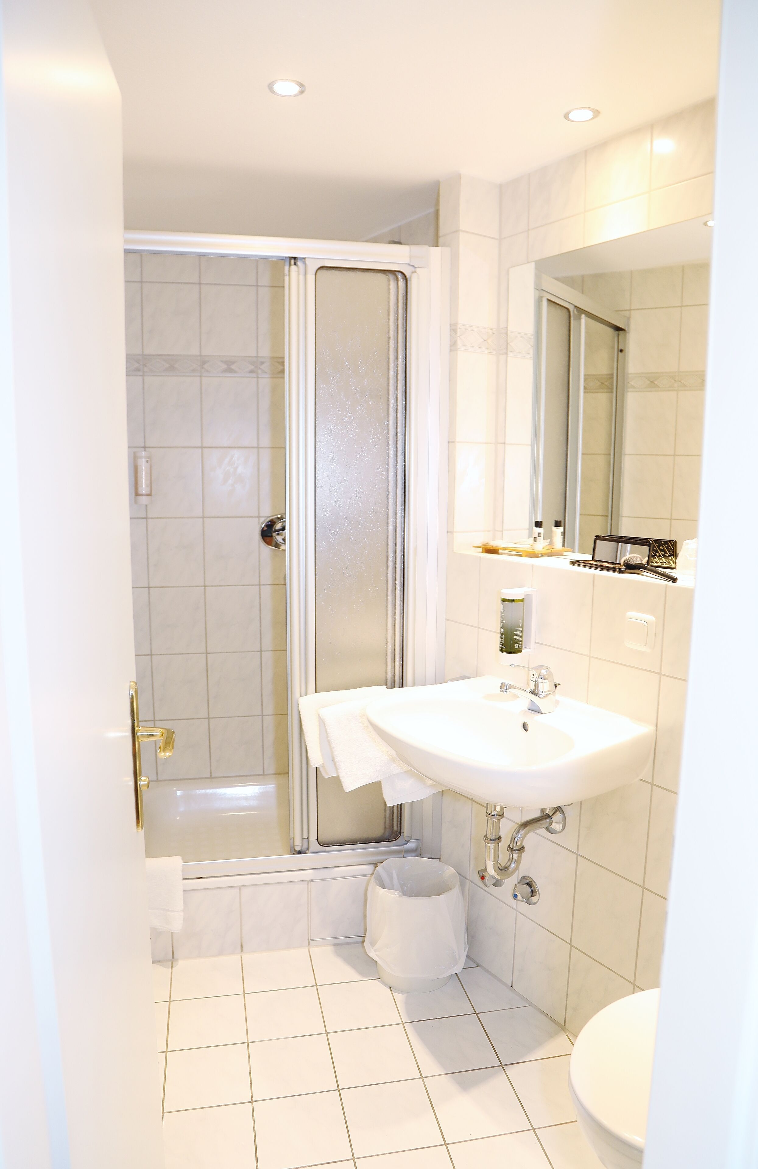 A bathroom with a shower, a sink, and a toilet.