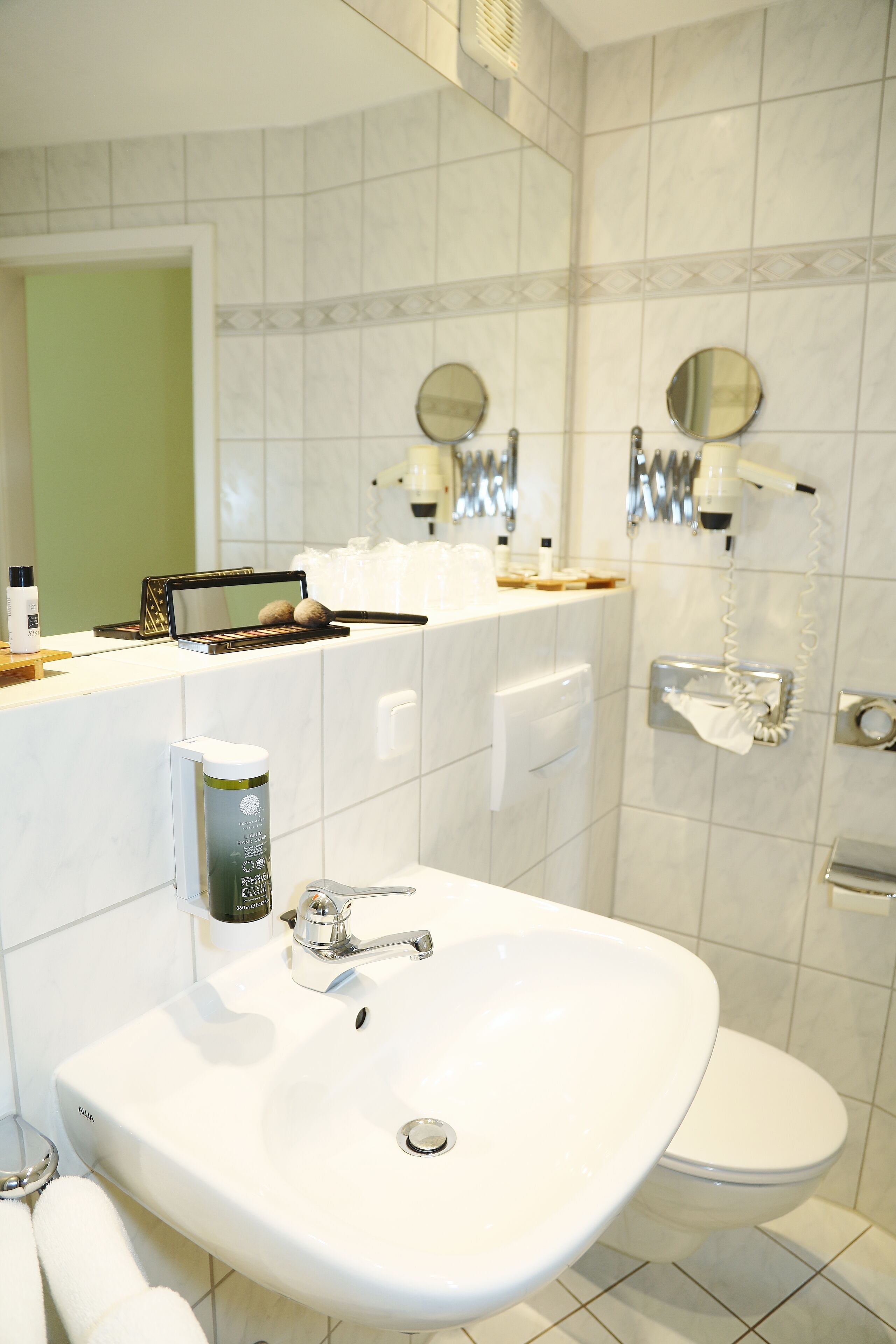 A bathroom with a white sink, a toilet, and a mirror above the sink.