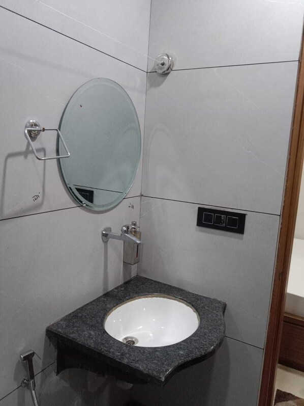 A bathroom with a white sink, a mirror, and a shower. - Gokul Dham Haridwar (Haridwar)