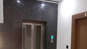 A modern elevator with a digital display, a wooden door, and a tiled floor. - Gokul Dham Haridwar (Haridwar)