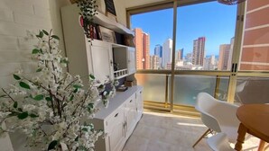 A balcony with a city view, a white cabinet, and a white chair. - CHARMING APARTMENT IN THE HEART OF LEVANTE (Benidorm)
