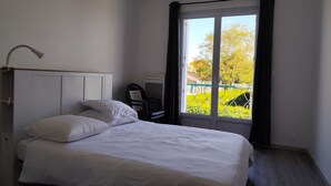 Une chambre à coucher avec un lit, un bureau et une fenêtre avec des rideaux.