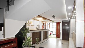 A reception area with a counter, plants, and a sign for 'CUGH Travel Inn Airport'. - Hotel CGH Travel INN Aeropuerto (Bogota)