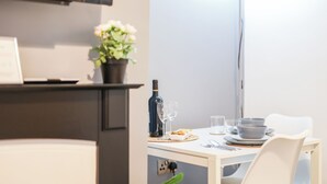 A dining area with a table set for two, a bottle of wine, and a potted plant. - Cosy 2-Bedroom Apartment, comfortably sleeps 5 (Gateshead)