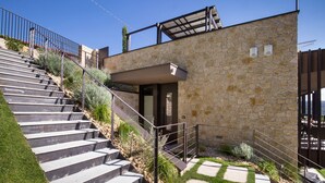 A staircase leading to a stone building with a metal railing and a covered outdoor area.