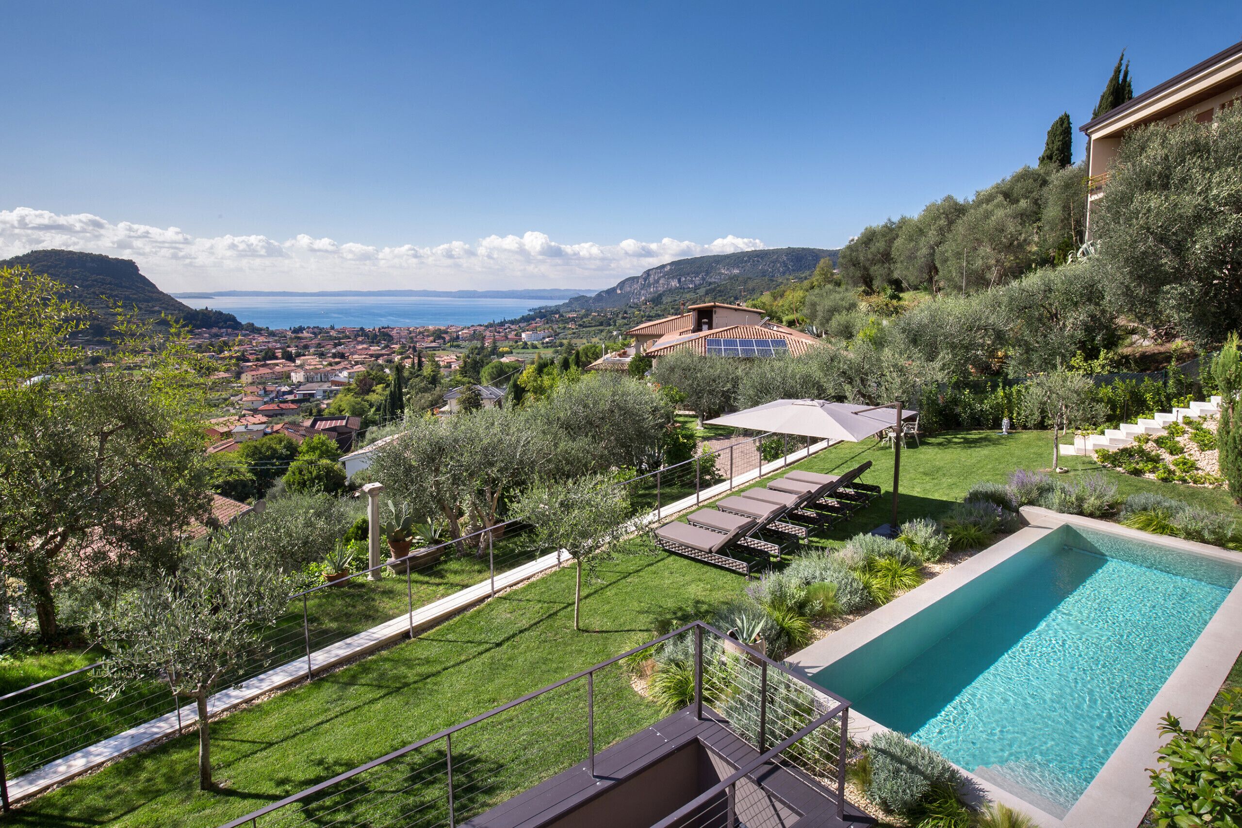 A swimming pool with a view of a coastal town and mountains.