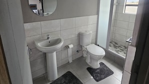 Ein Badezimmer mit Waschbecken, Toilette und Duschbereich.