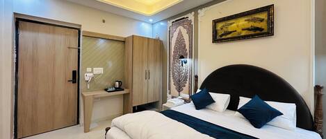 A bedroom with a bed, bedside table, wardrobe, and a decorative mirror.