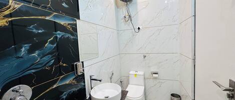 Un baño con pared de mármol, un lavabo, un inodoro y una ducha.