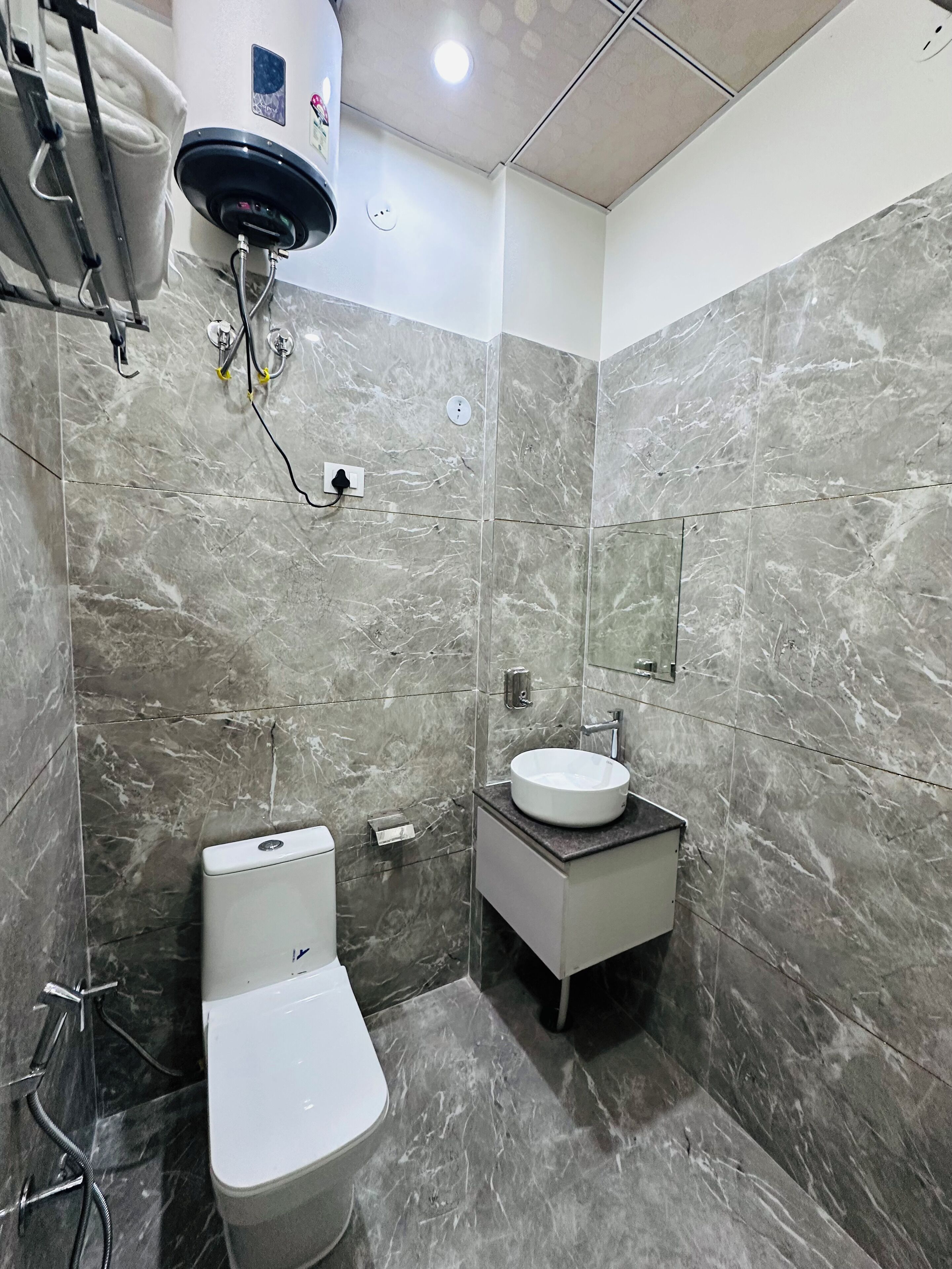 Een badkamer met toilet, wastafel en spiegel.