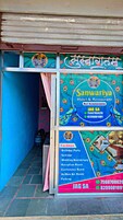 Un colorido letrero para el Hotel y Restaurante Sanuariya con números de contacto y una lista de servicios como una sala de fiestas y una sala de conferencias.