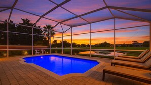 Ein überdachter Pool mit Blick auf einen Sonnenuntergang und einen Golfplatz.