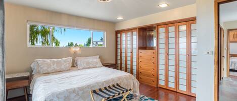 A bedroom with a bed, a window, a wardrobe, and a ceiling light.