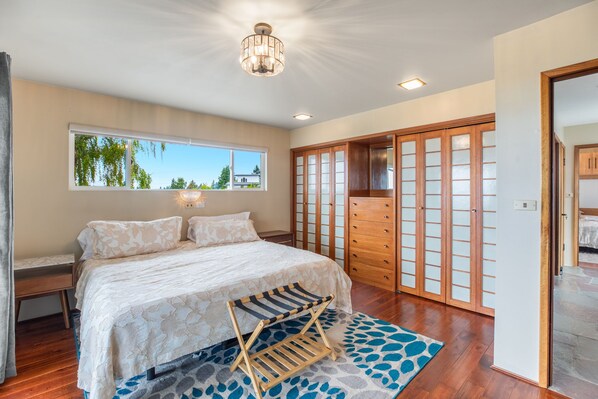 A bedroom with a bed, a window, a wardrobe, and a ceiling light.