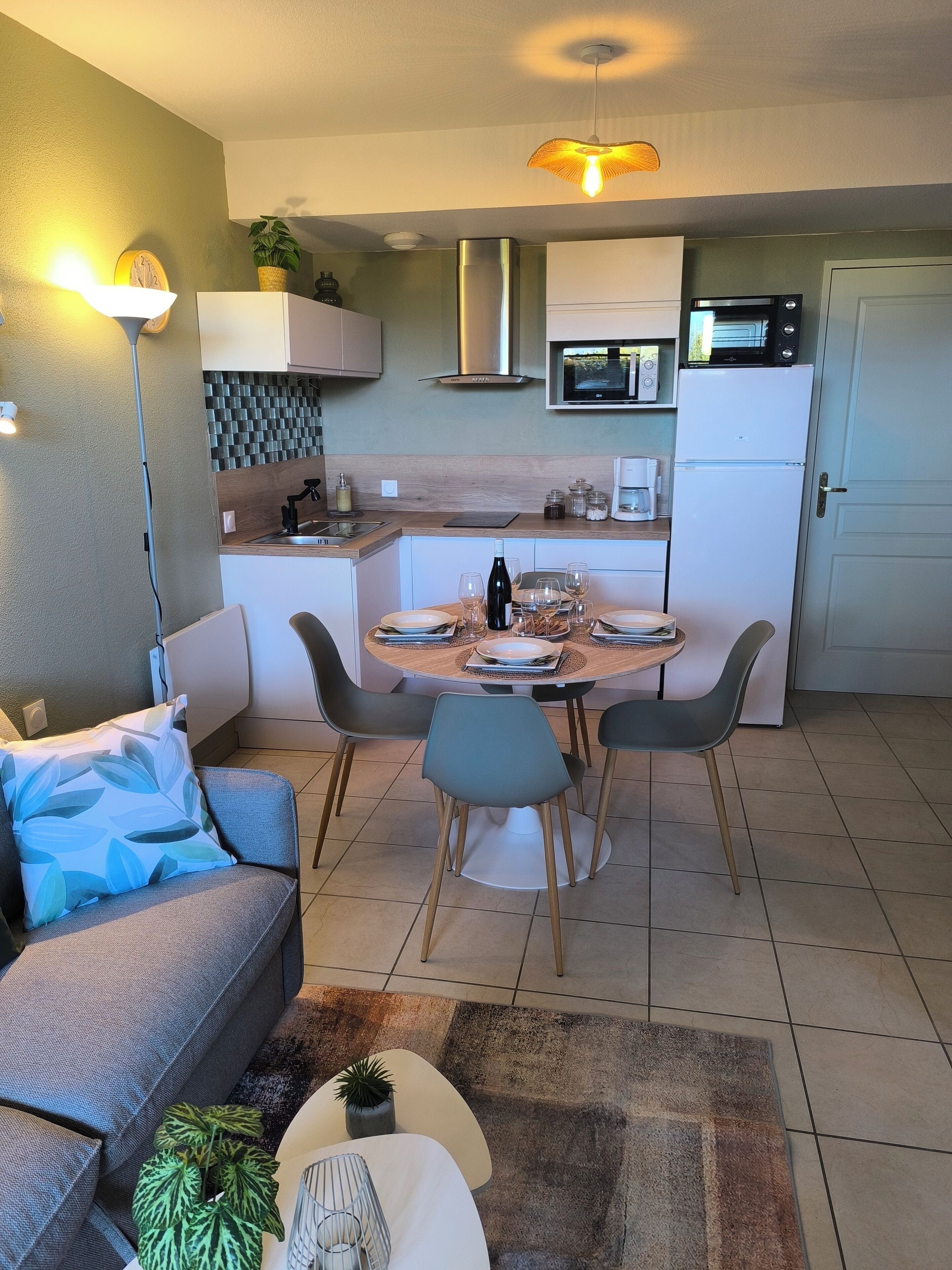 Een functionele leefruimte met een eethoek, kitchenette en zithoek.
