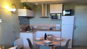 A compact living space with a dining area, kitchenette, and seating area.