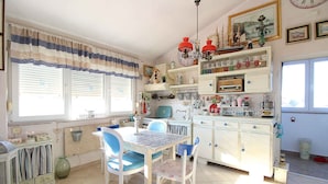Une cuisine équipée d’une table à manger, de chaises et de divers ustensiles de cuisine.
