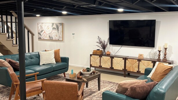 A modern living room with teal sofas, a coffee table, and a TV.