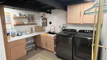Una cocina con armarios de madera, estufa negra, horno negro y encimera blanca.