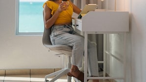 Une chambre avec vue sur la mer, un bureau avec une lampe et une chaise.