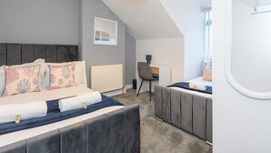 Ein modernes Schlafzimmer mit einem großen Bett, einem Schreibtisch und einem Sessel.