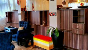 Une pièce avec un sol en pierre, un canapé, une table basse et une plante.