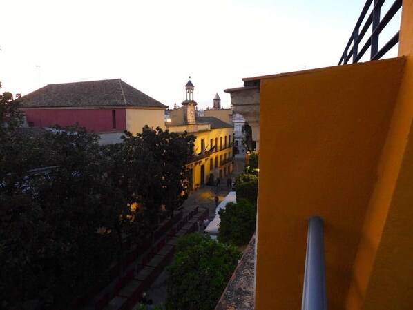 A view of a building with a bell tower and a staircase leading to a courtyard.