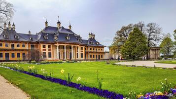 Ein großes, historisches Gebäude mit einer symmetrischen Fassade, zahlreichen Fenstern und einem zentralen Eingang.