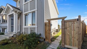 A residential house with a front porch, a wooden gate, and a pathway leading to the entrance. - Laurel Modern Haven (Edmonton)