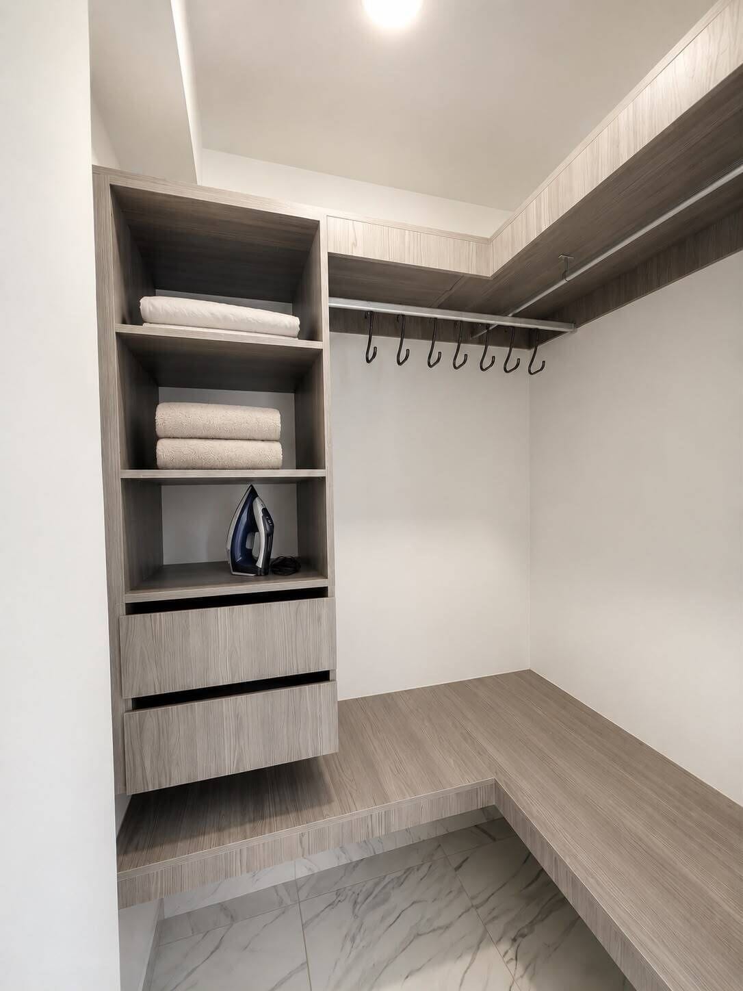 Un vestidor con estantes integrados, un banco y una barra para colgar.