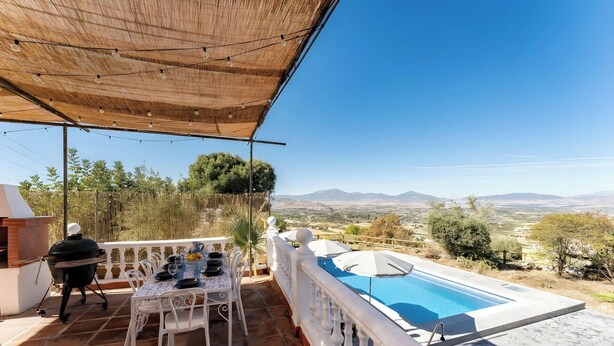 Eine Terrasse mit Pool, Sitzgelegenheit und Blick auf die Landschaft.