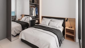 A modern bedroom with two beds, a built-in wardrobe, and a bedside table. - PORTO 2 LIFE RESORT - MARÉ ALTA (Ipojuca)