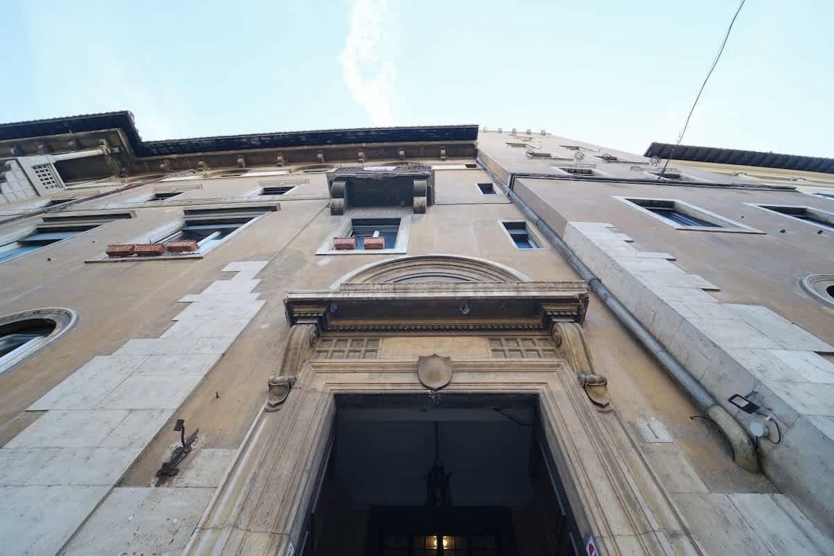 A building with a large central entrance, multiple windows, and a flat roof with skylights.