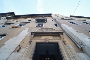 A building with a large central entrance, multiple windows, and a flat roof with skylights.