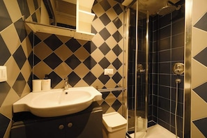 A bathroom with a sink, toilet, and shower.