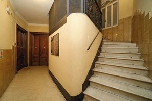 A hallway with a staircase, wooden doors, and a wall-mounted picture. - BuddyRent - Castel Sant'Angelo - 7 ospiti (Rome)