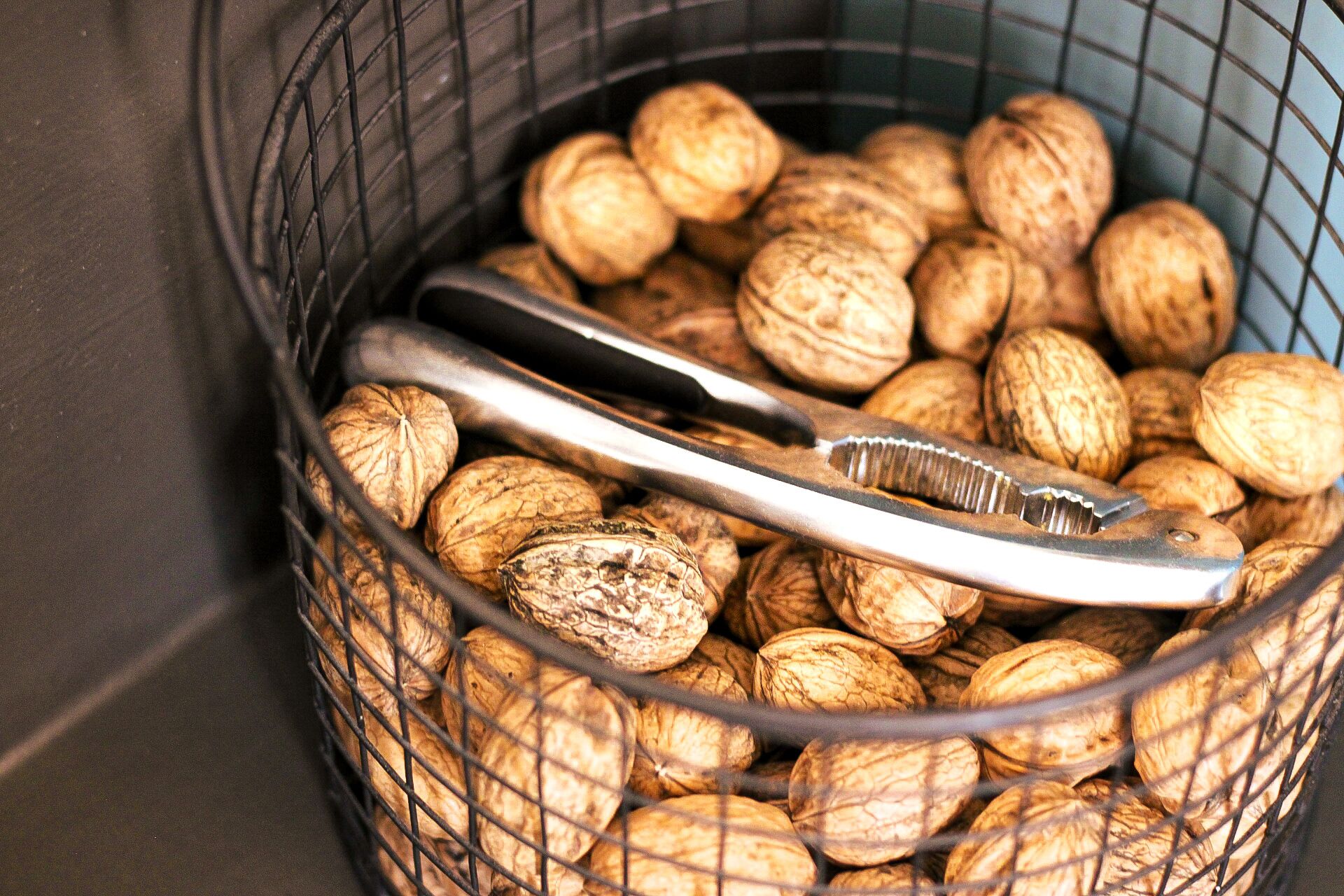 Una cesta con nueces y un par de pinzas.