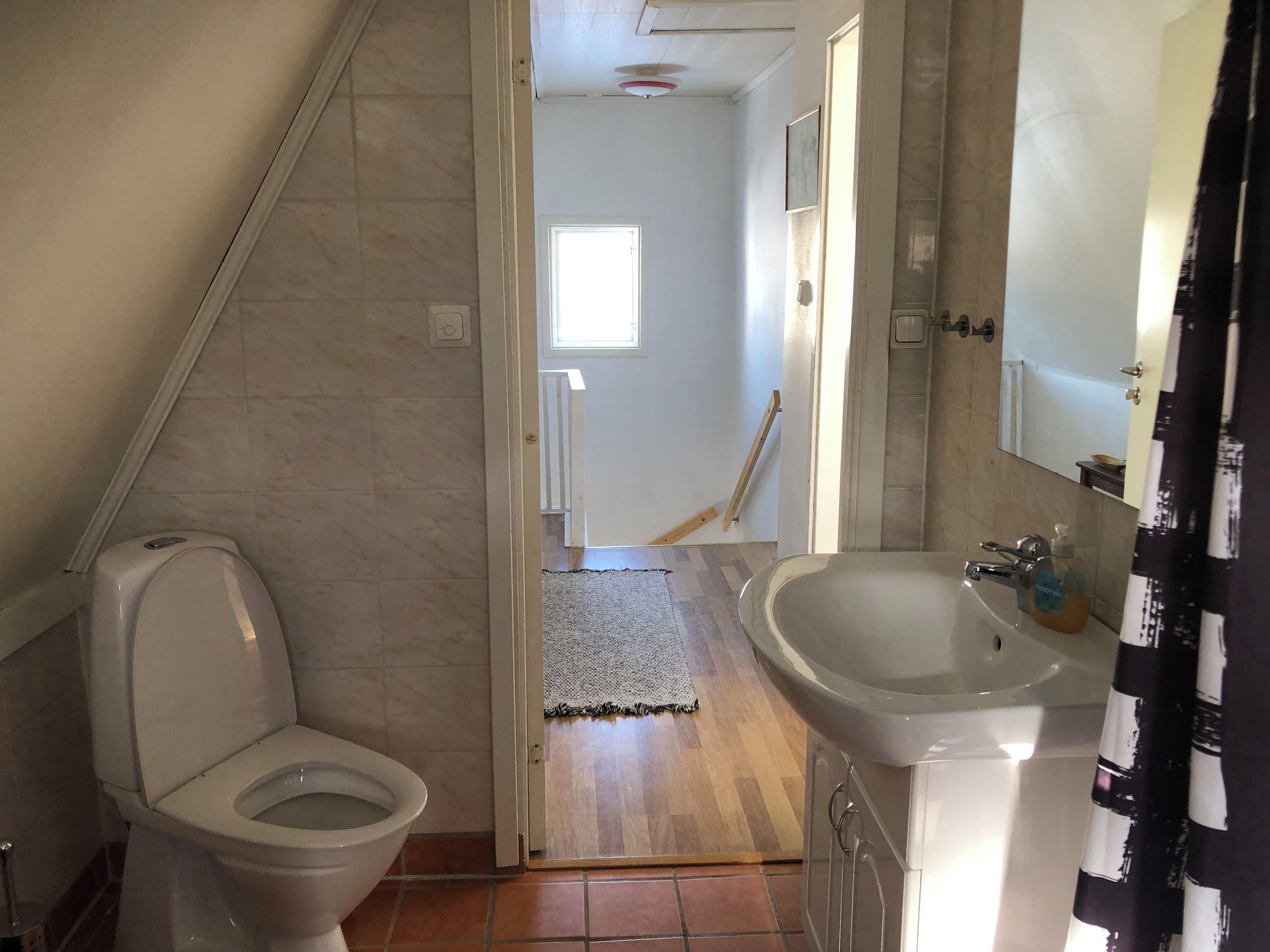 Une salle de bain avec des toilettes, un lavabo et un miroir.