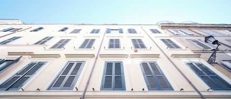 A building with multiple windows, a visible door, and a street lamp.