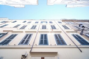 Un edificio con varias ventanas, una puerta visible y una farola.
