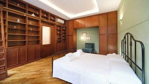 A bedroom with a bed, wooden shelving, and a desk. - BuddyRent - Dadada - Trevi - 8 ospiti (Roma)