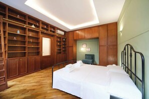 Un dormitorio con cama, estanterías de madera y un escritorio.