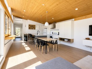 A modern kitchen with wooden flooring, a central island, and pendant lighting. - The Frāho Gorgeous View, No Neighbour SPA! (Grenville-Sur-La-Rouge)