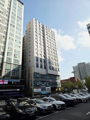 A multi-story building with a modern architectural design, featuring a mix of glass and concrete facades. - Ansan Modern Style Duplex - Kitchen & Washer (Ansan-si)