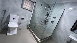Une salle de bain moderne avec une douche à parois de verre, des toilettes et un lavabo.
